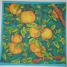 En primer plano hay unas naranjas en el árbol de color naranja sobre un fondo verde.